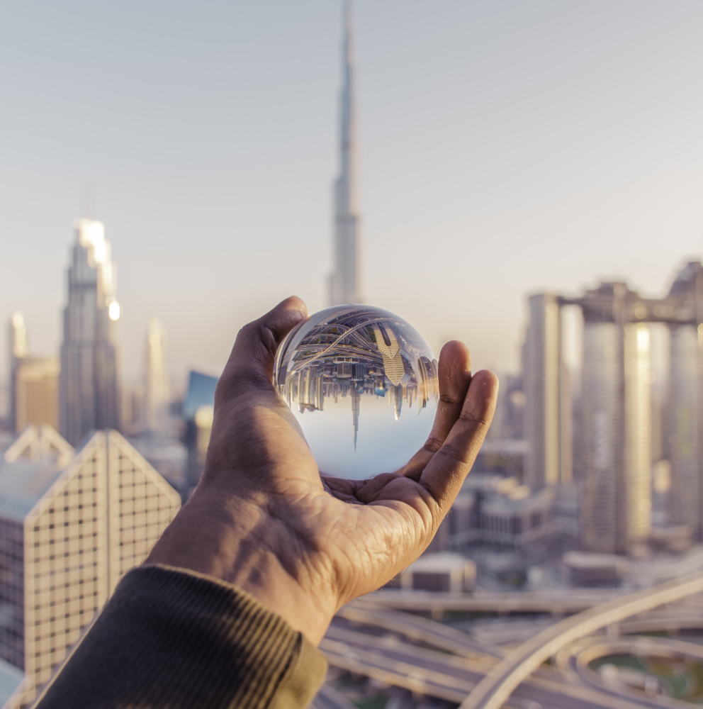 closeup-shot-male-hand-holding-crystal-ball-with-reflection-city (1)